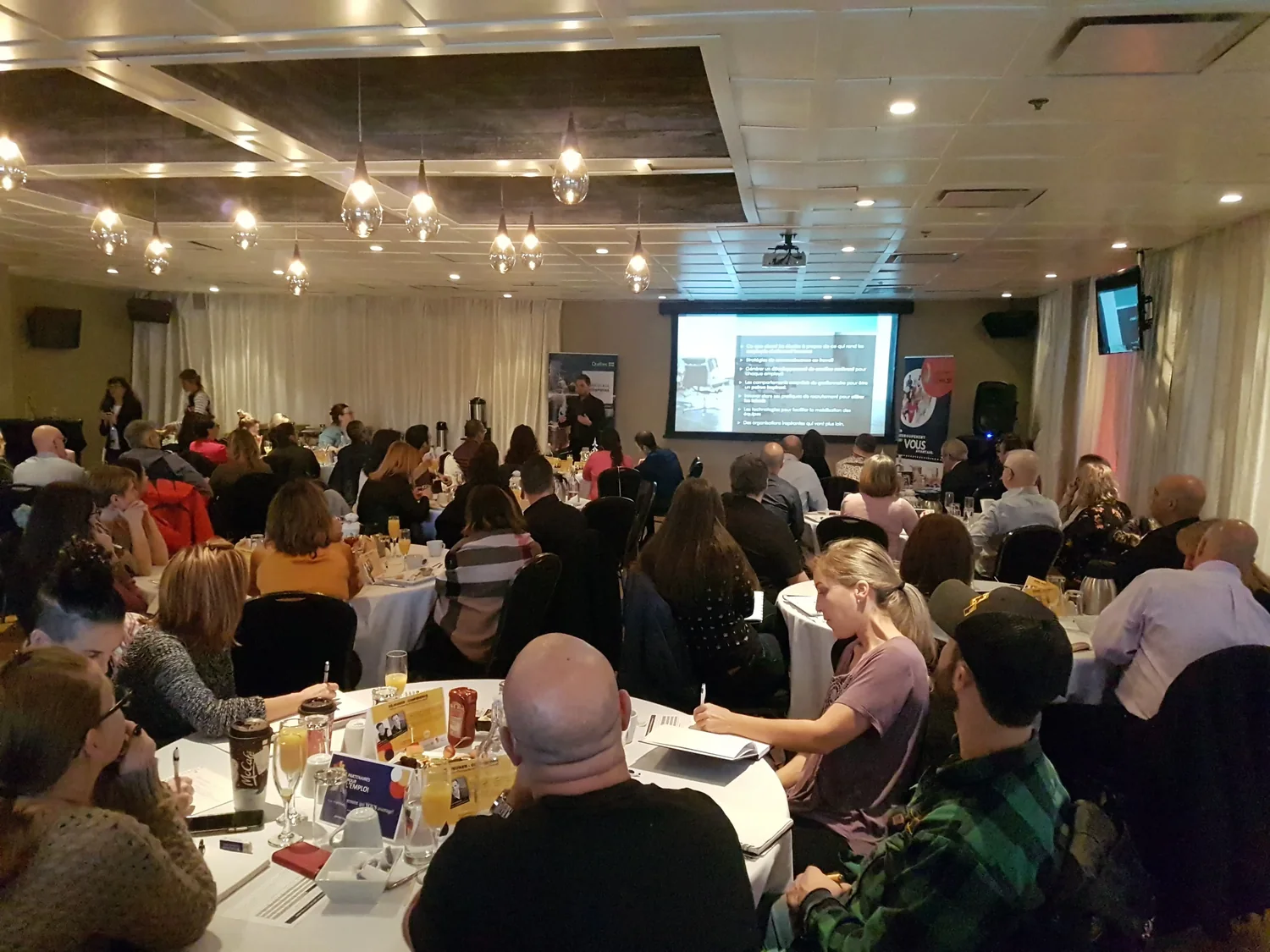Une salle comble de gestionnaires lors d'une conférence Amélio