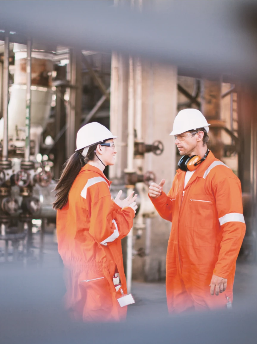Deux travailleurs de Contrôles Laurentide en discussion dans une usine, au cœur de cette étude de cas