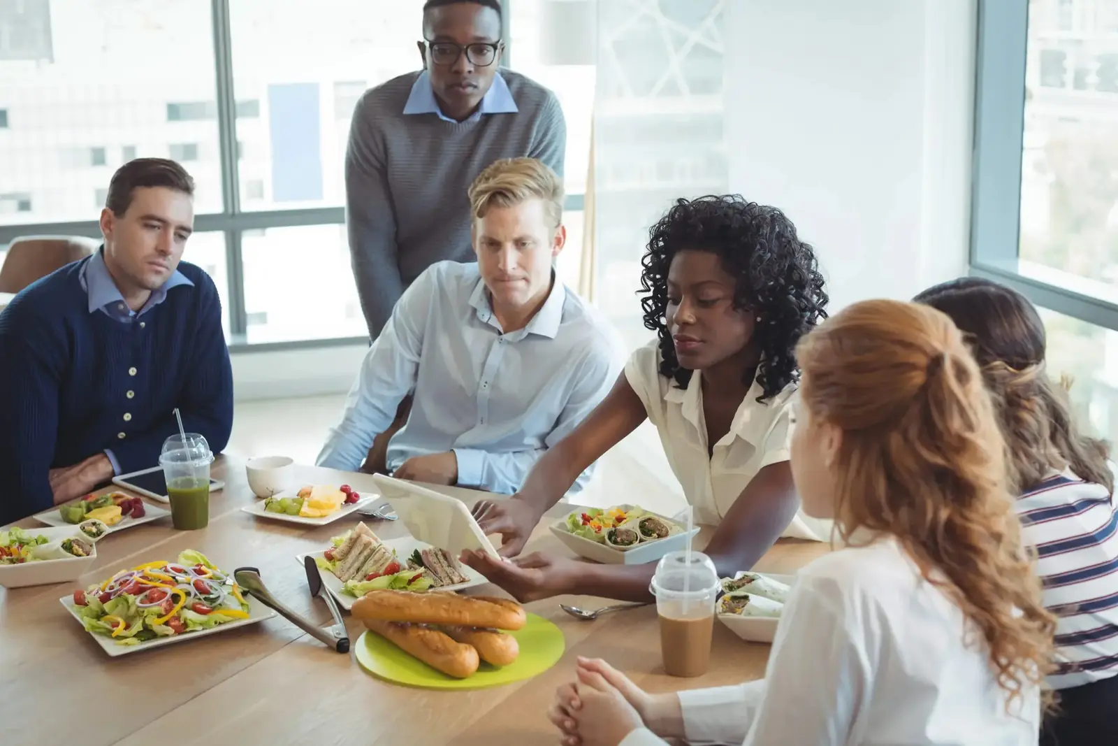 Collègues de travail en pleine discussion autour d'une table à la cafétéria du bureau